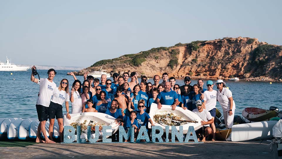 a group of people posing for a photo next to some boats