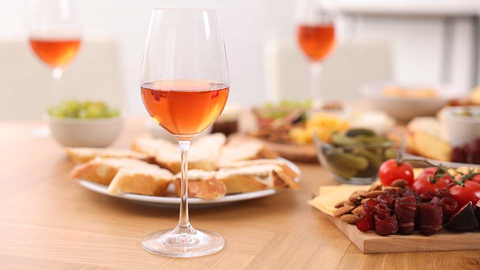 una mesa con comida y vasos de vino